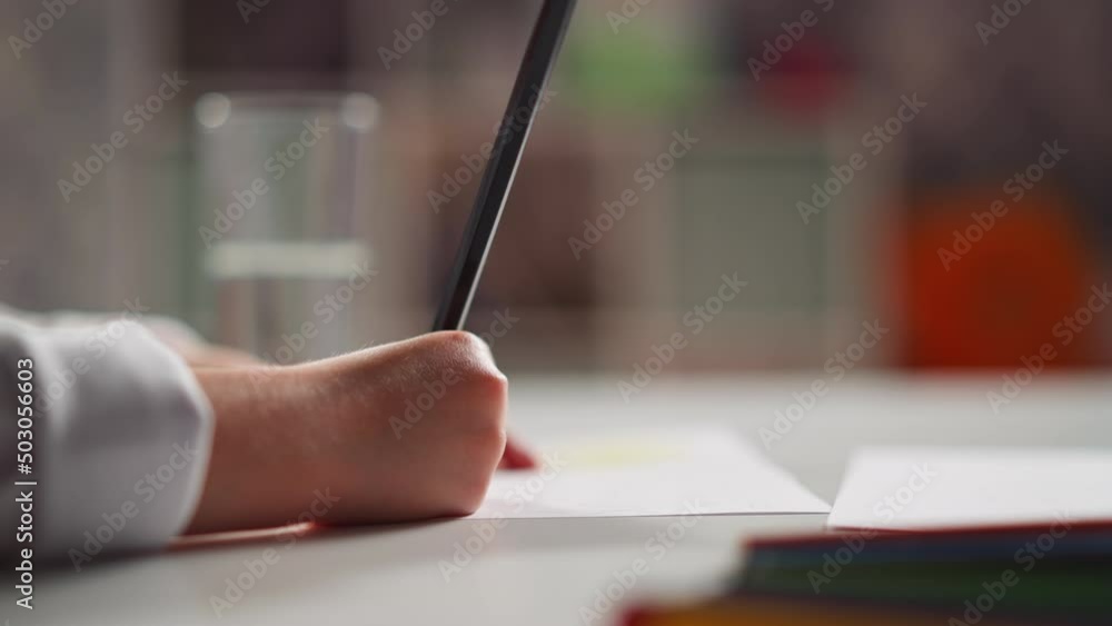 Little student draws picture on paper sheet and drinks mineral water at art lesson in kindergarten classroom close side view slow motion Little student draws picture on paper sheet and drinks mineral water at art lesson in kindergarten classroom close side view slow motion