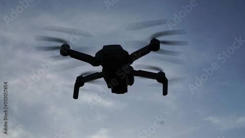 Flying quadcopter drone close-up against the backdrop of mountains and sunset. High quality 4k footage