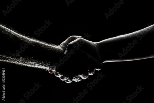 Handshake between the two partners, agreement. Male hands rescue. Friendly handshake, friends greeting, friendship. Rescue, helping gesture or hands. Helping hand.