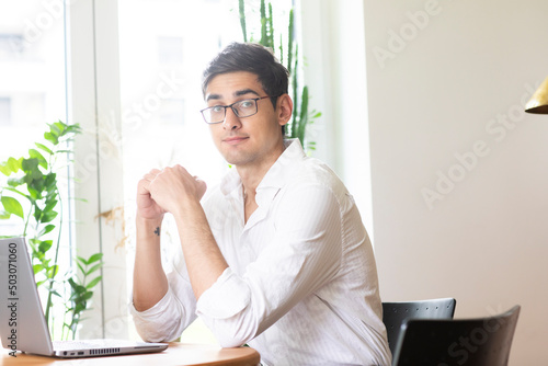 Junger Mann arbeitet in einem Büro mit grünen Pflanzen