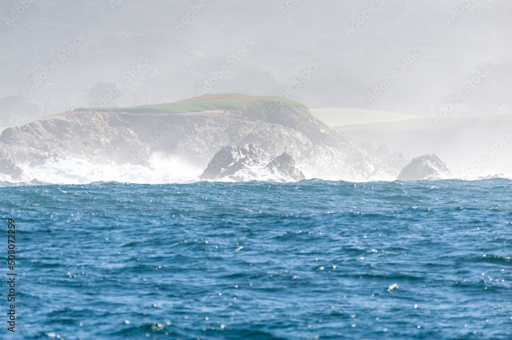 Rough seas off the californian coast breaking their waves against the steep cliffs.