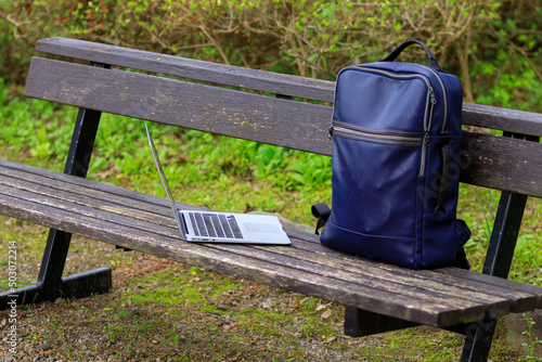 公園のベンチ ノートパソコンとリュック モバイル イメージ