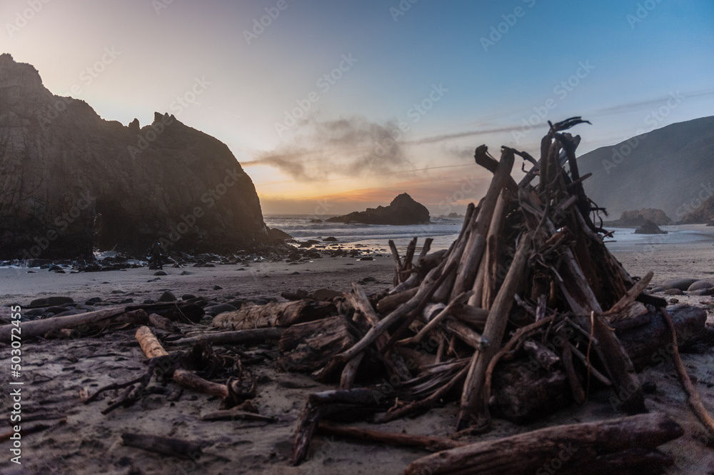 Close-up of a pile of firewood laying ashore on Pfeiffer Beach, around sunset.