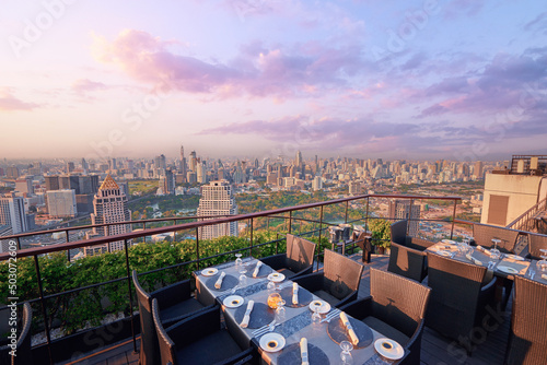 Photography Table setting on roof top restaurant with megapolis view, Bangkok Thailand