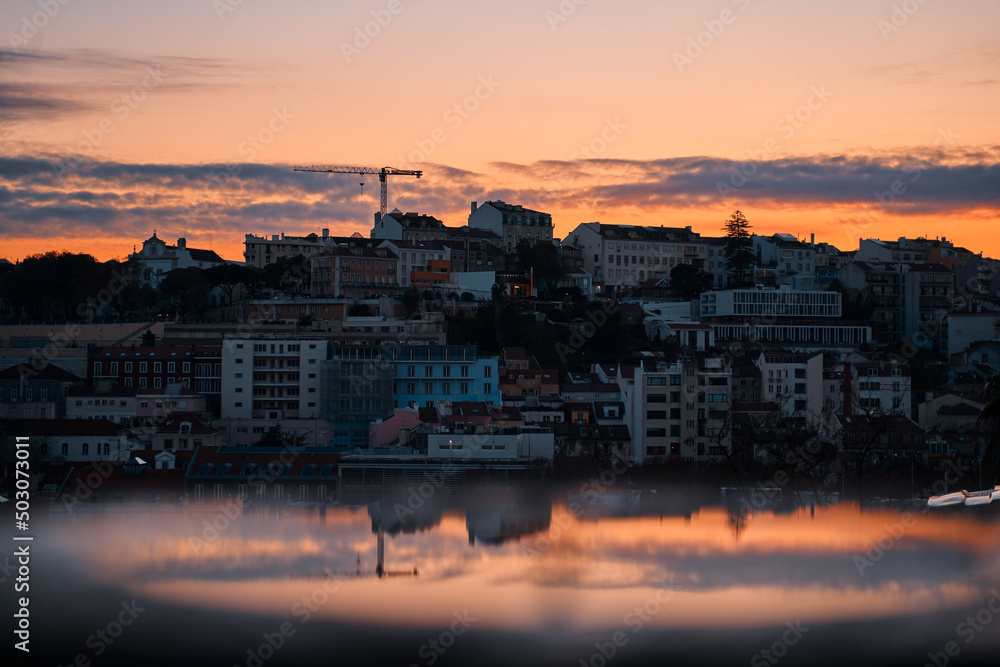 Beutiful view of old town in Lisbon. Red tiled roofs and sunset sky.