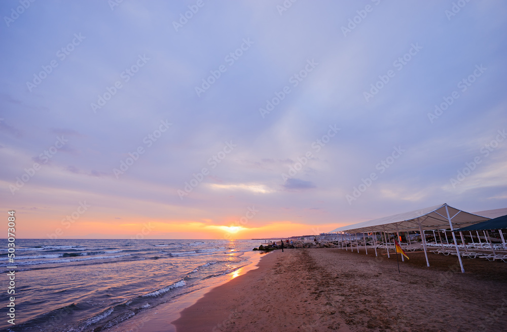 Beautiful sunset. Traveling by Turkey. Sea Beach with umbrellas.