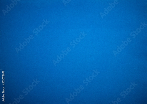 Photo of the texture of the blue fabric. Felt background is blue with a blue vignette. Blue background for text or ad.