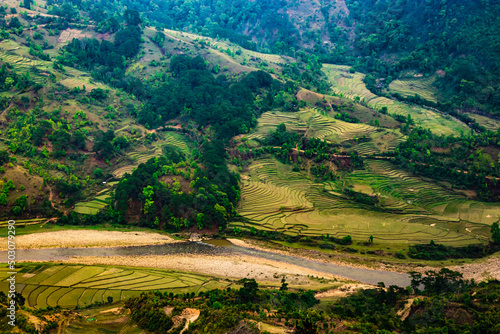 agriculture farming Fields with river flowing and surrendered by mountain at morning from top angle