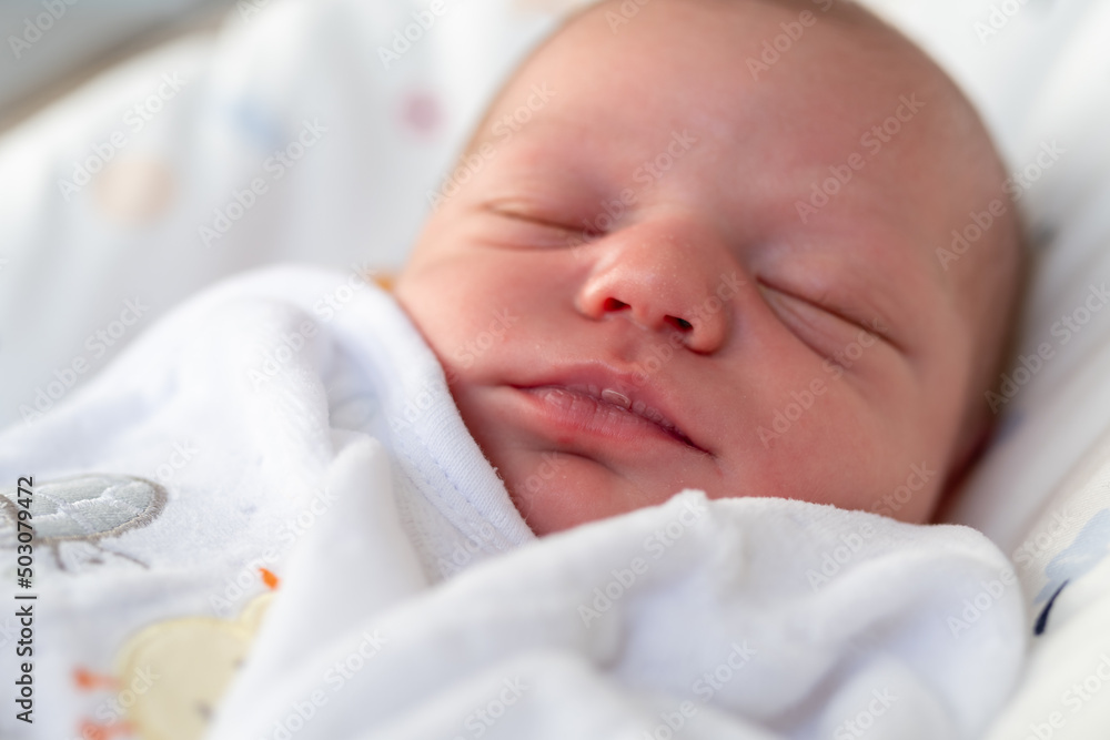 portrait of a newborn baby girl in soft white pajamas asleep in her crib after being fed breast milk portrait of a newborn baby girl in soft white pajamas asleep in her crib after being fed breast milk