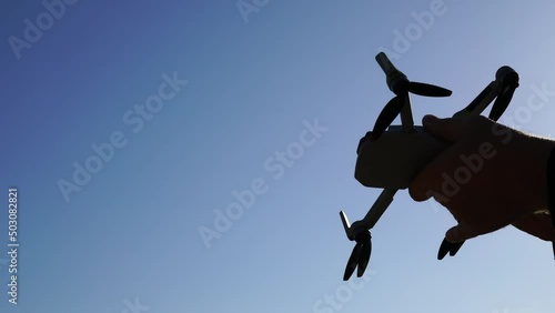Drone in hand. Quadcopter silhouette and close-up of hands. High quality 4k footage