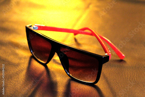 Photo of glasses with red handles. Stylish eyeglasses fashion accessories concept on black background.