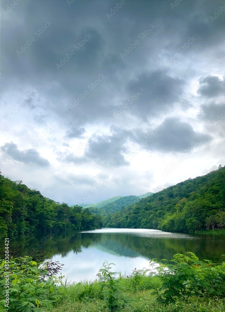 Beautiful natural scenery of mountains and river with rain clouds. Portrait wallpaper.
