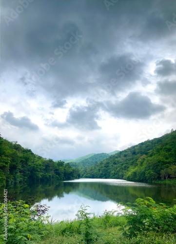 Beautiful natural scenery of mountains and river with rain clouds. Portrait wallpaper.