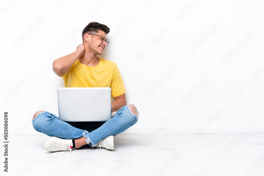 Young man sitting on the floor isolated on white background with neckache Young man sitting on the floor isolated on white background with neckache
