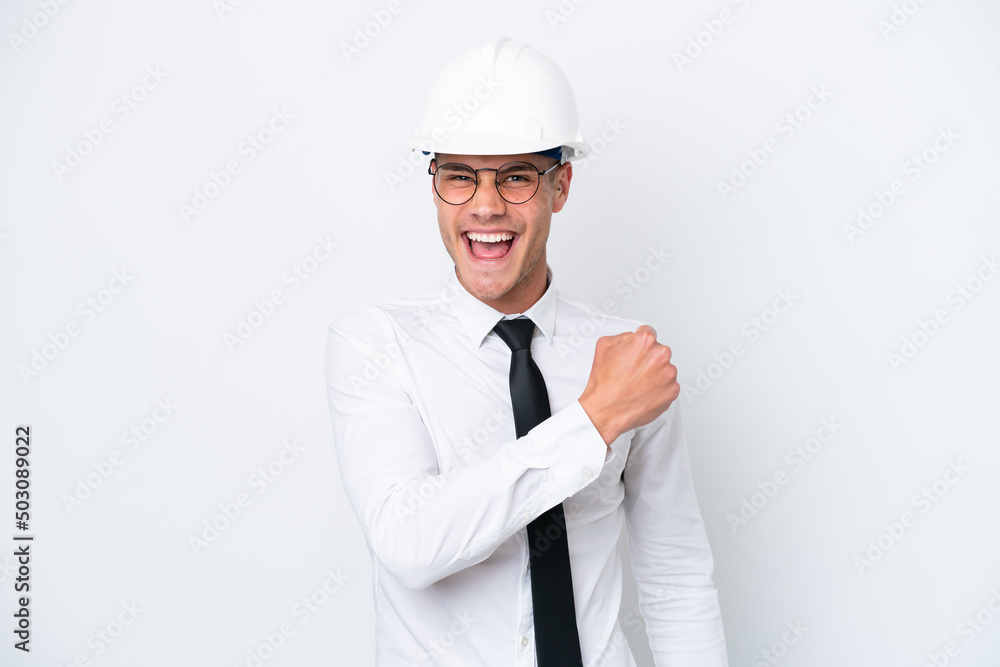 Young architect caucasian man with helmet and holding blueprints isolated on white background celebrating a victory Young architect caucasian man with helmet and holding blueprints isolated on white background celebrating a victory