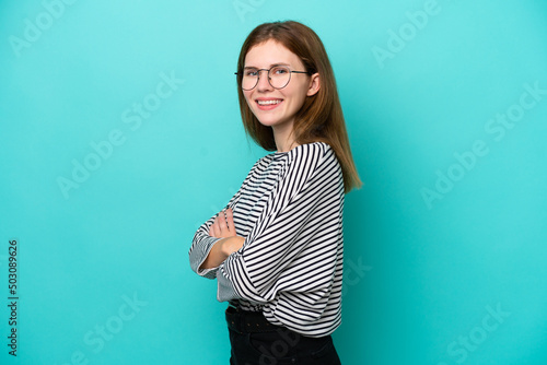 Young English woman isolated on blue background with arms crossed and looking forward