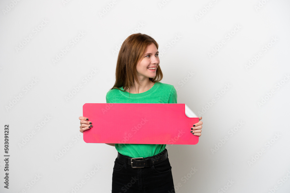 Young English woman isolated on white background holding an empty placard and looking side Young English woman isolated on white background holding an empty placard and looking side