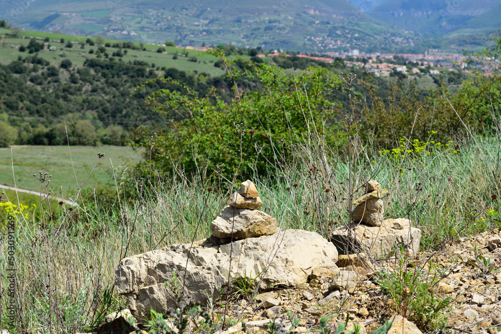 Fototapeta premium Abstract collection of rocks with a mountain village in the background