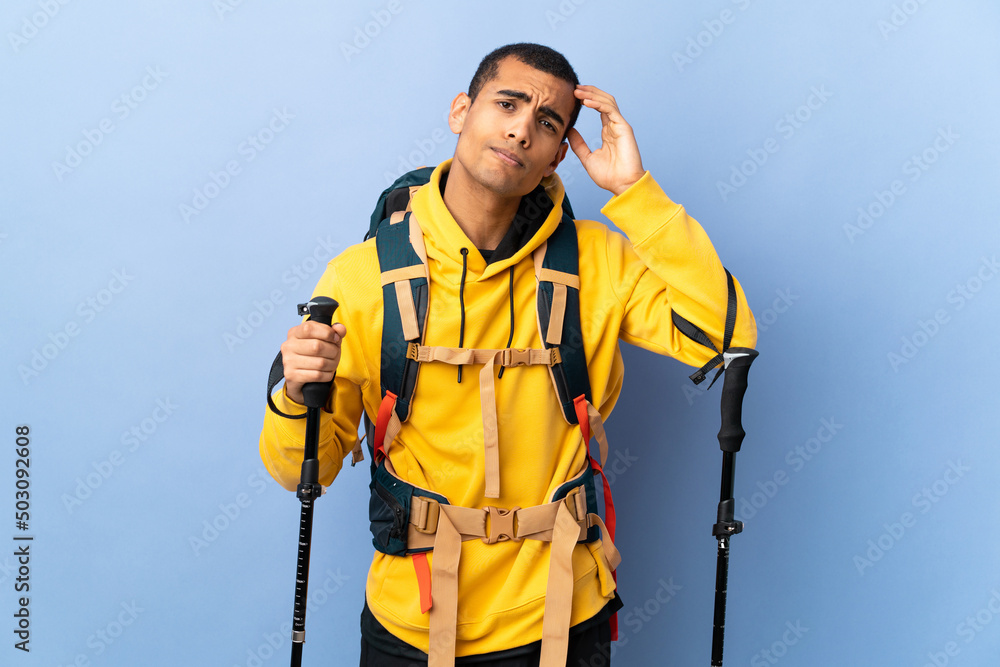 African American man with backpack and trekking poles over isolated background with an expression of frustration and not understanding African American man with backpack and trekking poles over isolated background with an expression of frustration and not understanding