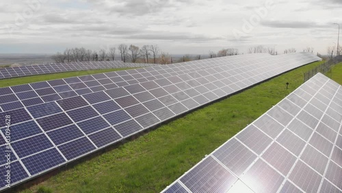 Array of solar power panels on sunset. Sky reflection on panels. Green energy in Ukraine. Ecological sustainable energy for Europe. Low angle