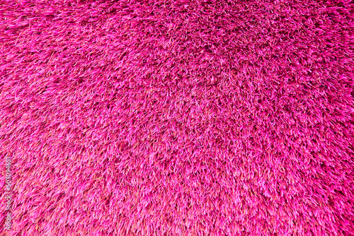 Background of pink texture of artificial grass cover, seamless background.