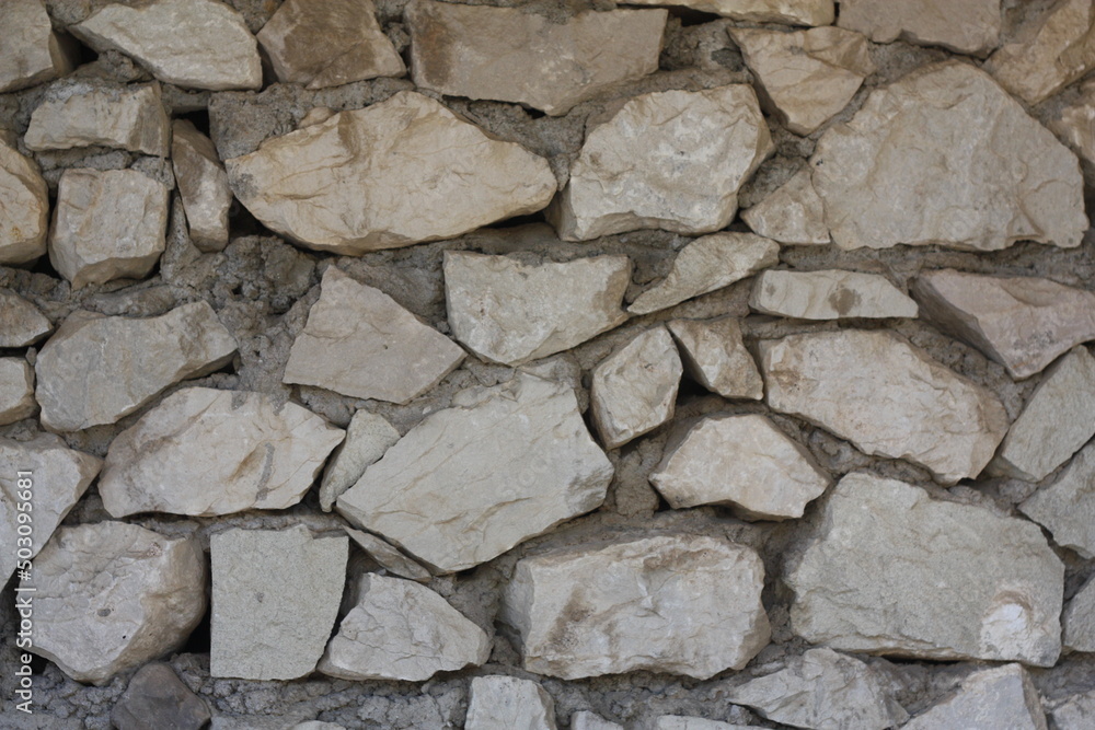 Background of limestone masonry. The surface is decorated with natural material. The wall is made of wild stone. Background of limestone masonry. The surface is decorated with natural material. The wall is made of wild stone.