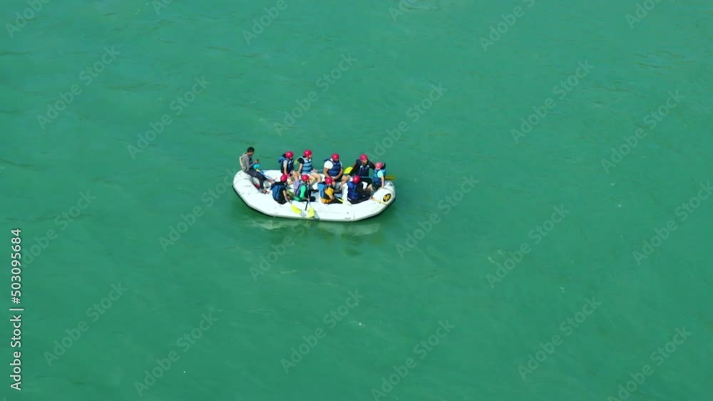 raft boat with people at the middle of ganges river from top angle raft boat with people at the middle of ganges river from top angle