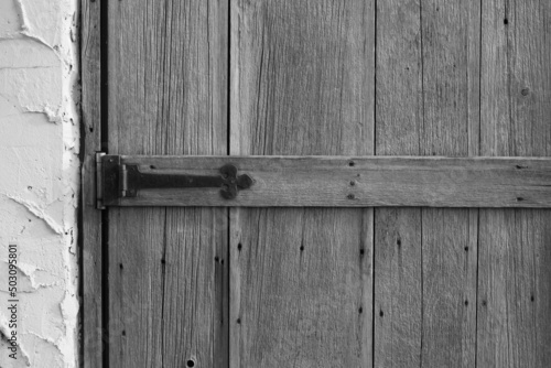 Old wooden door worn down by lots of use in black and white monochrome.