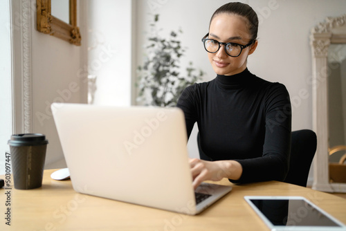 Freelancer manager surf the internet. A woman working in an office uses a laptop. Writes a letter to the client by mail.