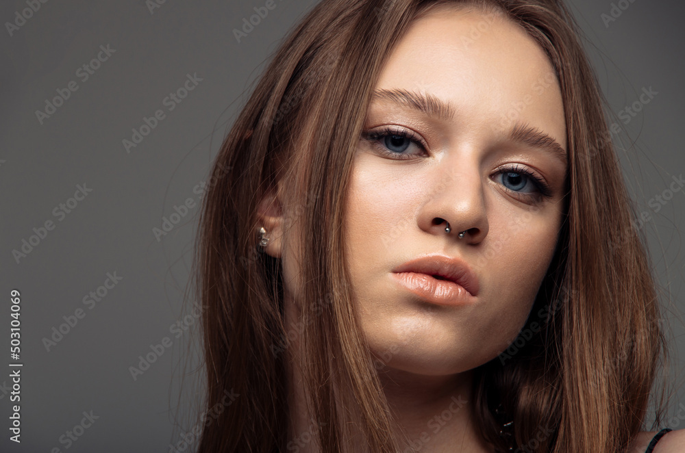 Portrait beautiful model posing in studio over grey background. Caucasian portrait woman. Portrait beautiful model posing in studio over grey background. Caucasian portrait woman.