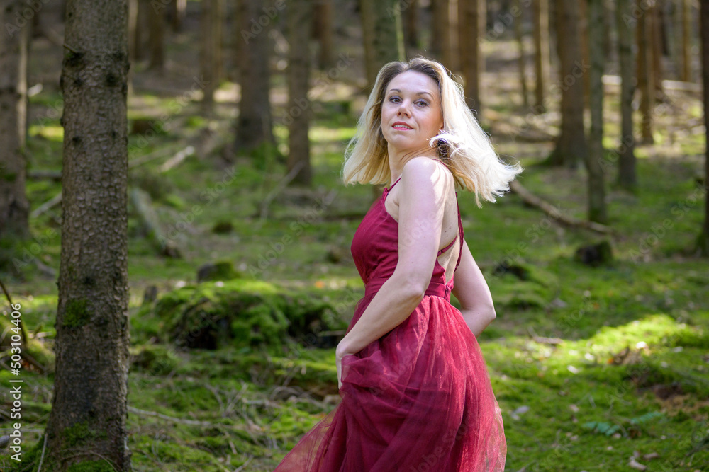 Pretty blond woman turning around against trees in woods. Pretty blond woman turning around against trees in woods.