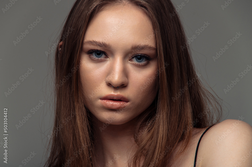 Portrait beautiful model posing in studio over grey background. Caucasian portrait woman. Portrait beautiful model posing in studio over grey background. Caucasian portrait woman.