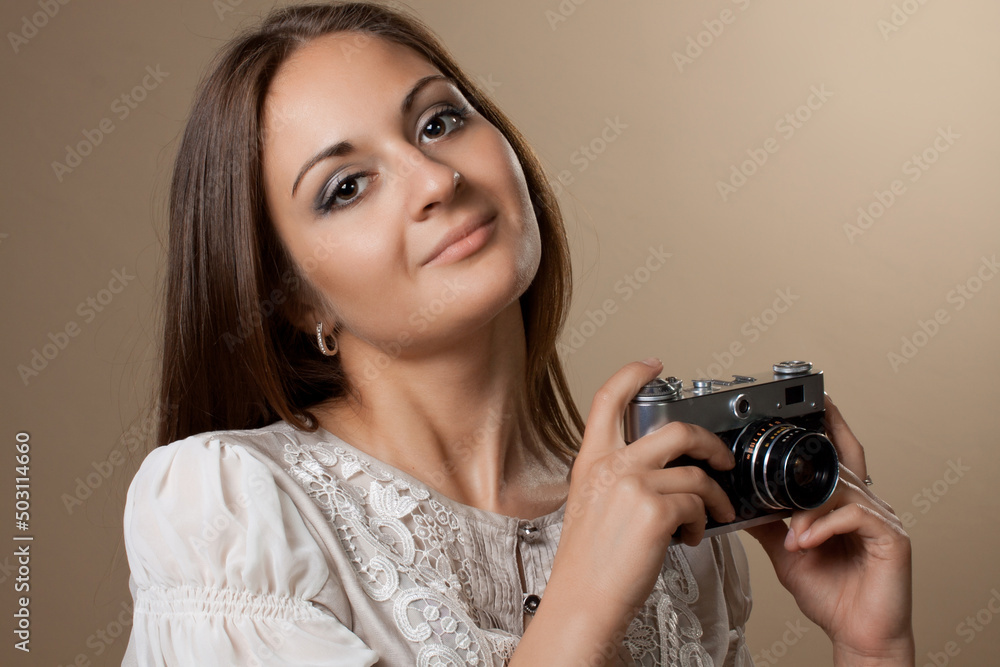Young brown haired woman in beautiful dress holding retro camera Young brown haired woman in beautiful dress holding retro camera