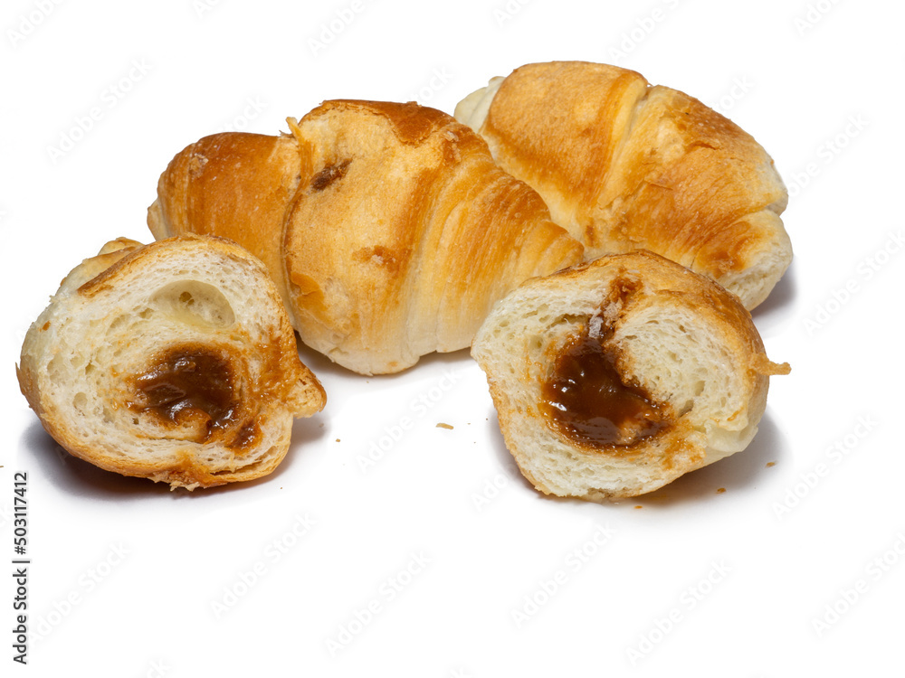 Many small croissants on a white background. Croissants with boiled condensed milk. Confectionery in the kitchen. Many small croissants on a white background. Croissants with boiled condensed milk. Confectionery in the kitchen.