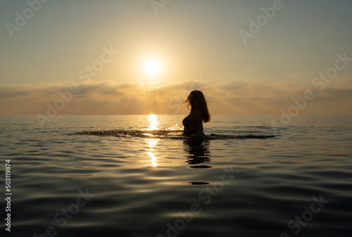 The women stands in the water and makes waves