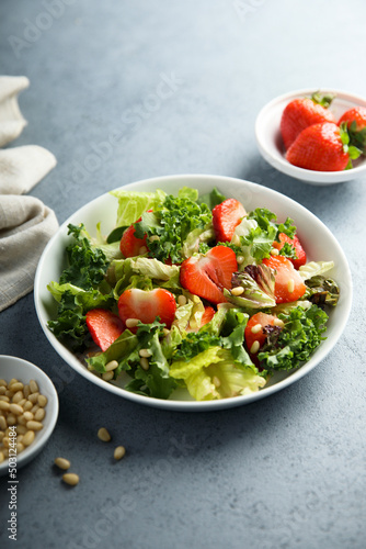 Healthy green salad with strawberry and pine nuts