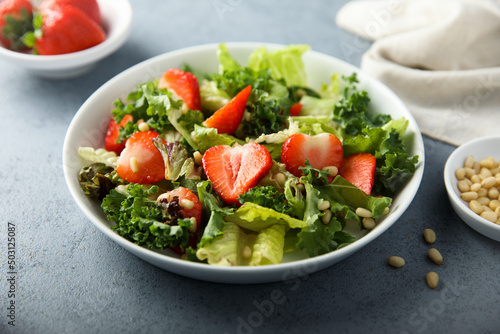 Healthy green salad with strawberry and pine nuts
