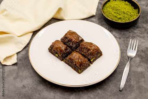 Chocolate baklava. Chocolate baklava with pistachio on dark background. Mediterranean cuisine delicacies. Close-up. local name cikolatali baklava photo