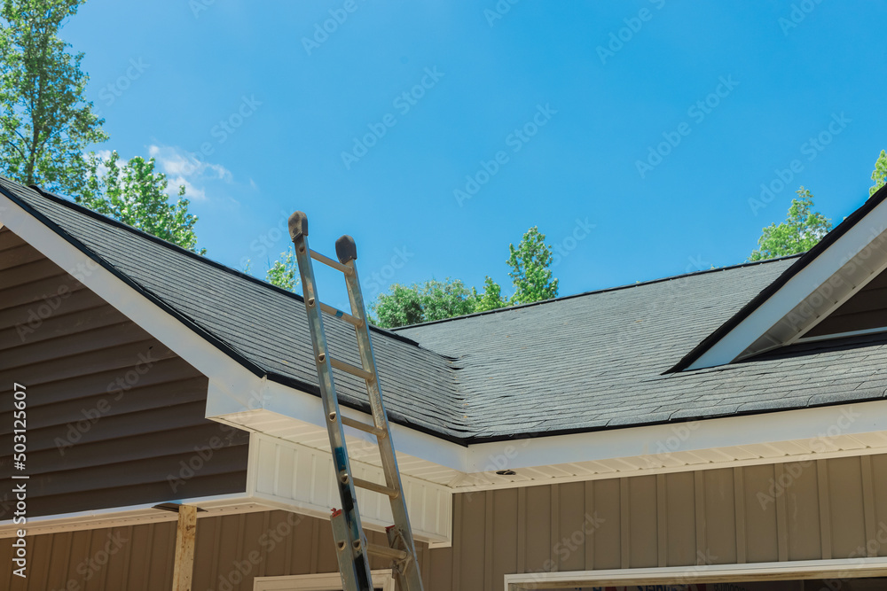 Aerial view of newly installed roof with asphalt shingles with bitumen tiles on new home the rooftop Aerial view of newly installed roof with asphalt shingles with bitumen tiles on new home the rooftop