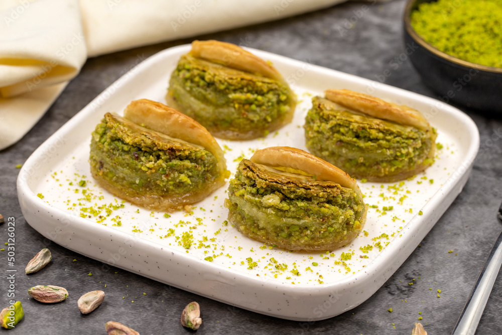 Pistachio baklava. Baklava with pistachio on a dark background. Mediterranean cuisine delicacies. Close-up. local name dilber dudagi baklava Pistachio baklava. Baklava with pistachio on a dark background. Mediterranean cuisine delicacies. Close-up. local name dilber dudagi baklava