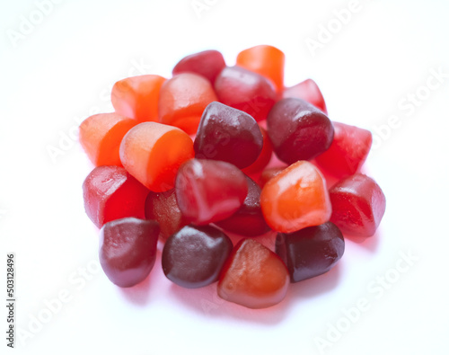 Group of red, orange and purple multivitamin gummies isolated on white background