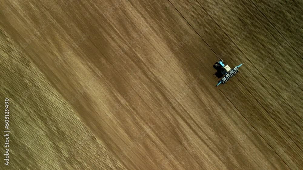 Spring agricultural land. Tractor with a cultivator on a spring field. Aerial photography. Spring agricultural land. Tractor with a cultivator on a spring field. Aerial photography.
