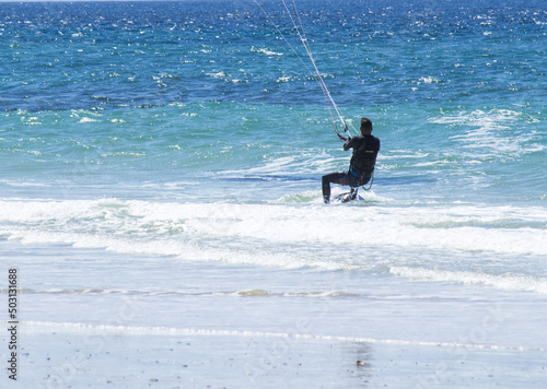 Young man kitesurfing on a beach