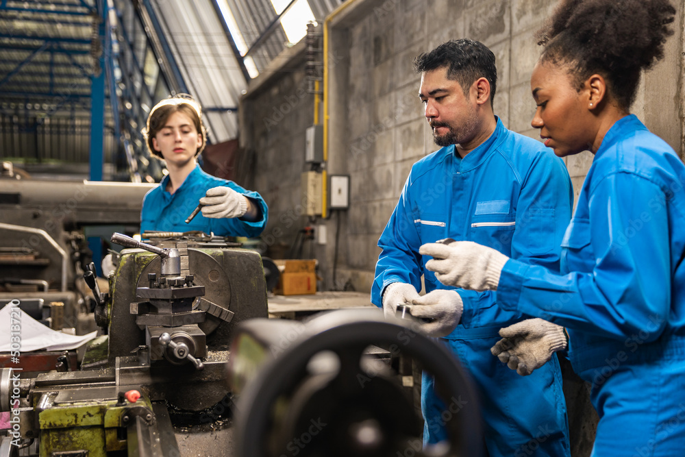 Senior asian engineer man and african american woman worker in protective uniform operating machine at factory Industrial.Teamwork working in industry. Senior asian engineer man and african american woman worker in protective uniform operating machine at factory Industrial.Teamwork working in industry.