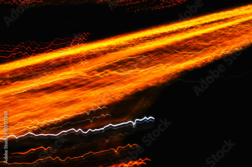 Futuristic abstract optical layers of orange lights on a dark background photo