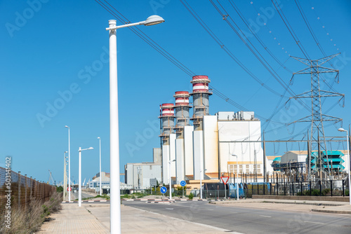 three chimneys of a power plant on a clear day against a clear sky