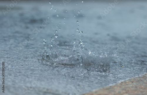 Rain drops on the ground and water splashes. Stationary water distribution.