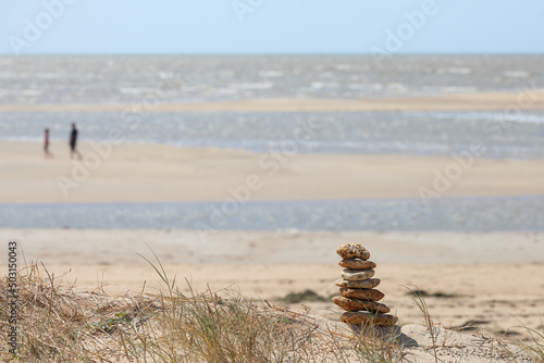 Canvas Print Selective focus shot of stacked stones on a sandy beach
