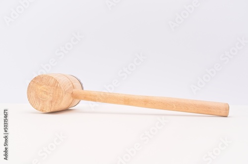 wooden mallet isolated on white table against white wall