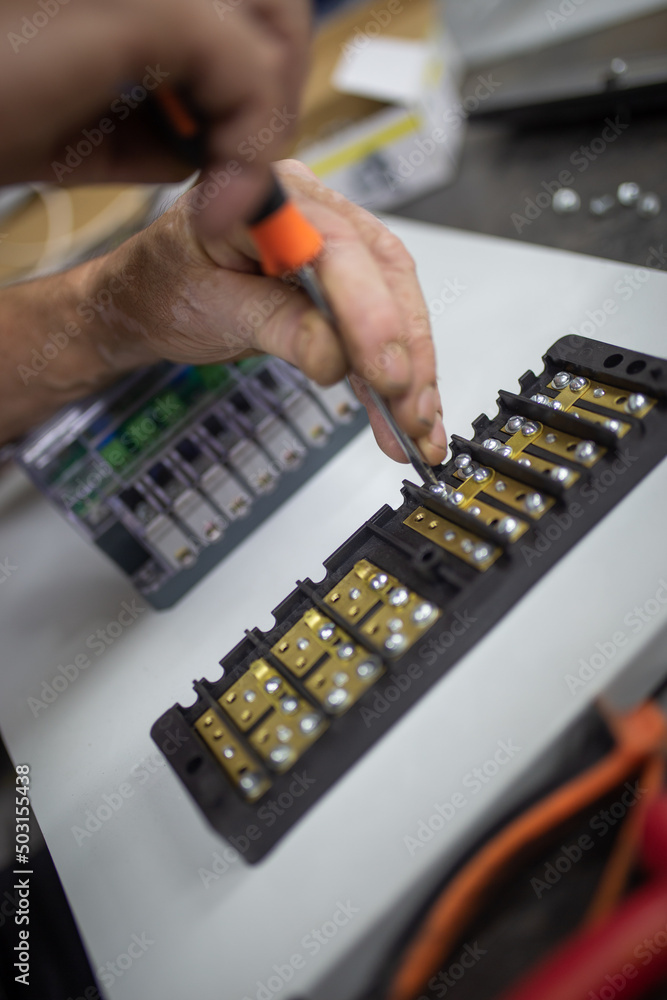 hands of a worker in close-up with a screwdriver, tightening bolts hands of a worker in close-up with a screwdriver, tightening bolts